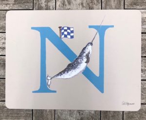 table mat with a letter N in blue decorated with illustration of a narwhal and a nautical code flag 'N' makes a lovely gift for Nicholas or Nancy.