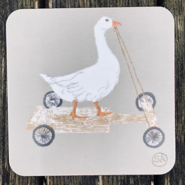 white goose riding an old wooden go-cart
