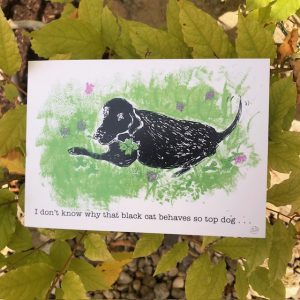 Good luck card of a black labrador dog holding a four leaf clover which he has found you ! Text outside reads I don't know why that black cat behaves so top dog ... ' inside text continues ' look what I have found you !Good luck