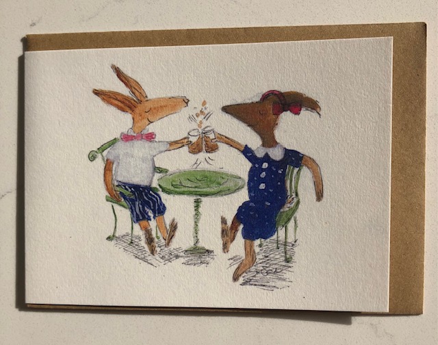 2 hare friends clink glasses and say cheers! sitting around a cafe table at last.
