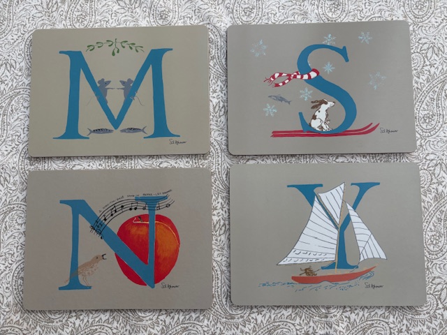 a photo of 4 placemats each with a different letter, illustrated with animals beginning with the letter they illustrate: M for mice, S for spaniel, N for Nightingale, Y for Yak
