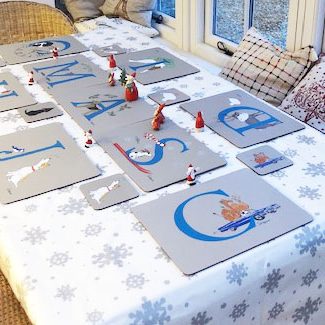 a Christmas table setting displaying my illustrated placemats with matching coasters and decorated with mini Father Christmases.